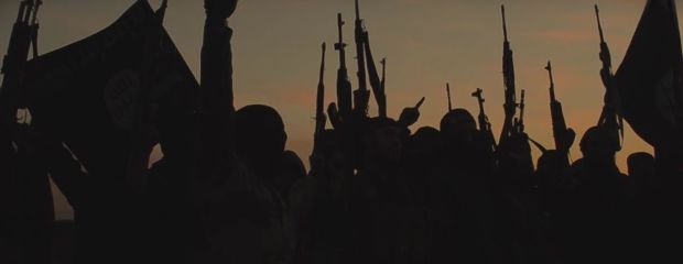 Das Bild zeigt Kämpfer der Terrororganisation Islamischer Staat (IS) mit Waffen und Fahnen.