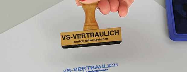 Das Bild zeigt einen Stempel mit der Aufschrift "VS-VERTRAULICH - amtlich geheimhalten". Das Bild zeigt einen Stempel mit der Aufschrift "VS-VERTRAULICH - amtlich geheimhalten".